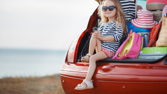 girl on vacation sitting in packed car